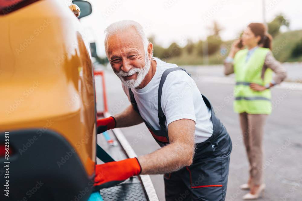 Handsome senior man working in towing service on the road. Roadside assistance concept. Handsome senior man working in towing service on the road. Roadside assistance concept.