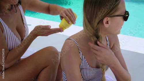 CU Mother applying suntan lotion on daughter (12-13) / Majorca, Spain