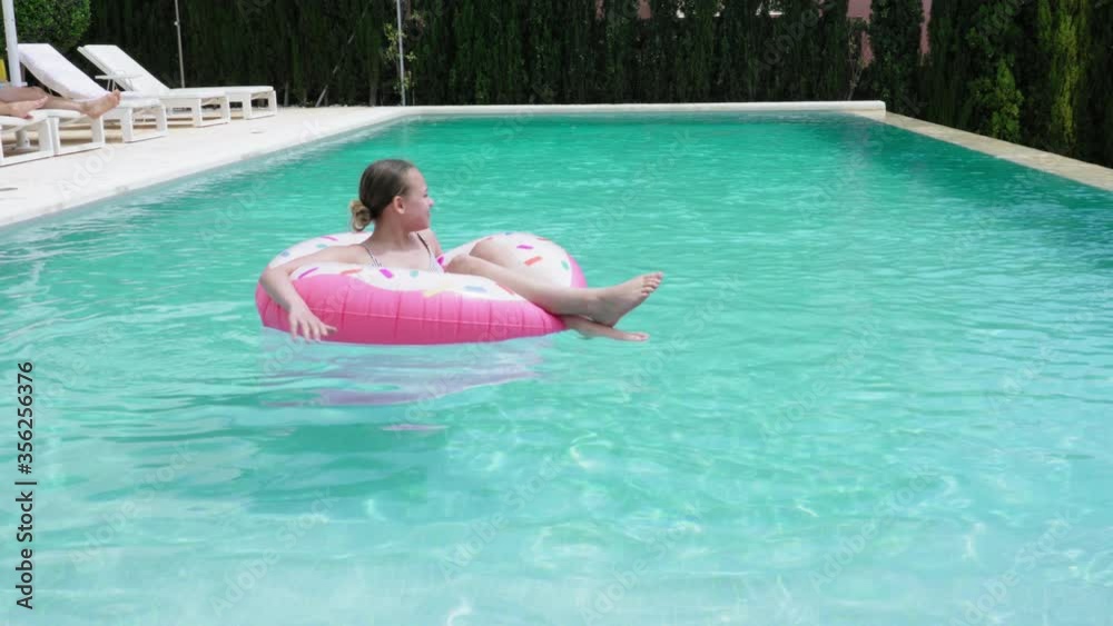 MS Girl (12-13) floating in pool on pool raft / Majorca, Spain MS Girl (12-13) floating in pool on pool raft / Majorca, Spain
