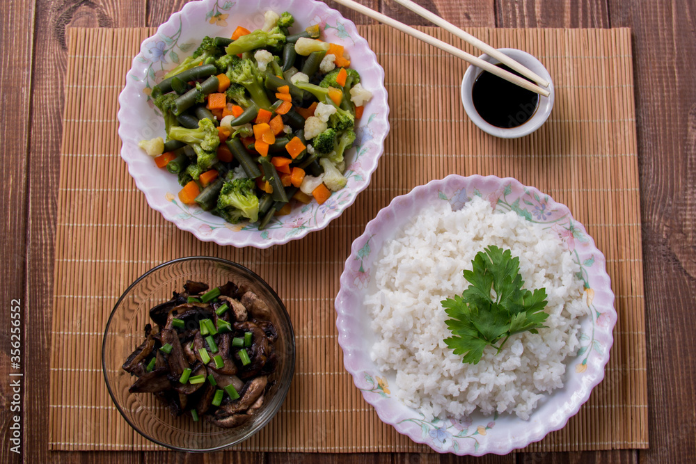 Rice with soy sauce and boiled vegetables close-up on a decorative background. Rice Dish. Fried mushrooms. Healthy eating Vegetarian food. Vegetarian dish Rice with soy sauce and boiled vegetables close-up on a decorative background. Rice Dish. Fried mushrooms. Healthy eating Vegetarian food. Vegetarian dish