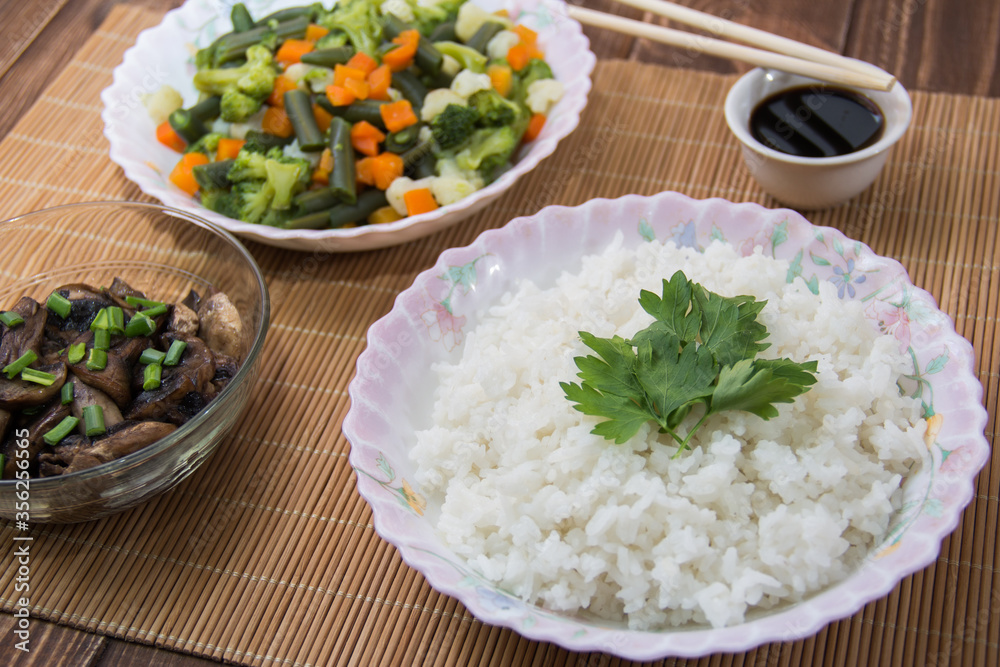 Rice with soy sauce and boiled vegetables close-up on a decorative background. Rice Dish. Fried mushrooms. Healthy eating Vegetarian food. Vegetarian dish Rice with soy sauce and boiled vegetables close-up on a decorative background. Rice Dish. Fried mushrooms. Healthy eating Vegetarian food. Vegetarian dish