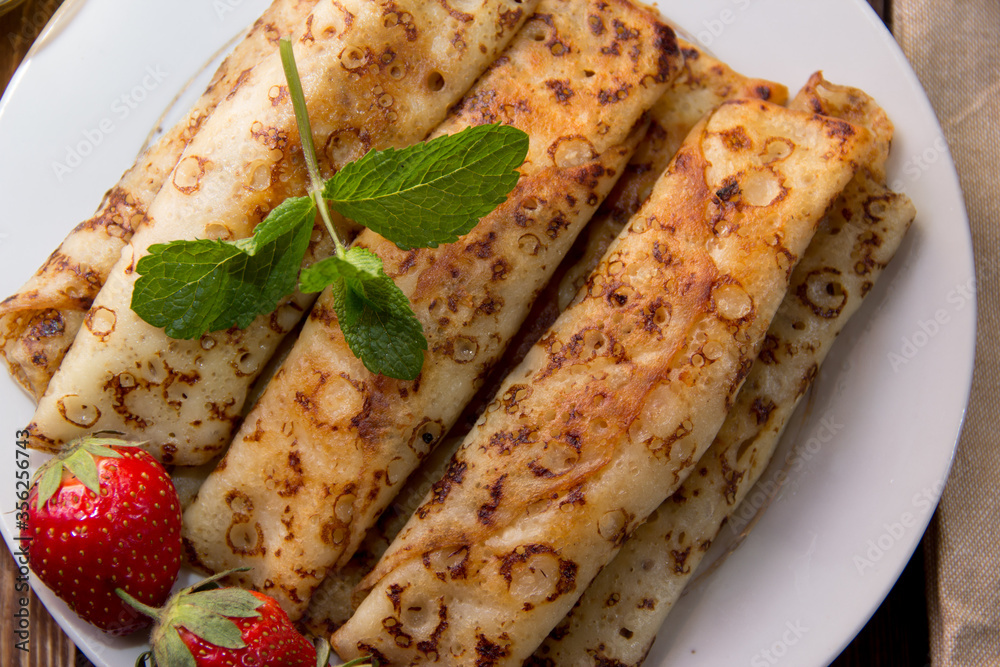 fried pancakes and strawberries closeup on a wooden table. Dessert. Healthy breakfast. Proper nutrition