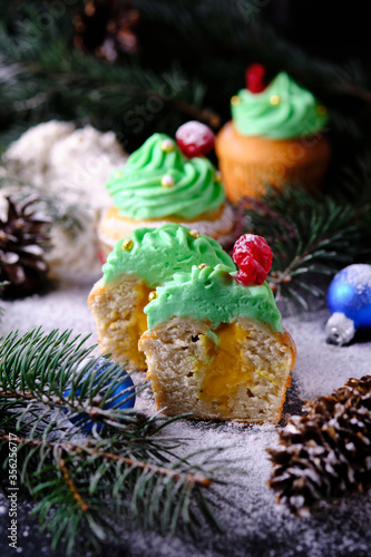 Halves of Christmas muffins stuffed with tangerine Kurd in a festive and snowy forest. Dessert for New Year and Christmas celebration.