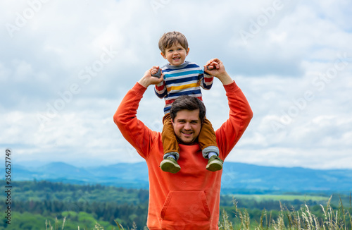 Father with son walking at outdoor with mountains on background