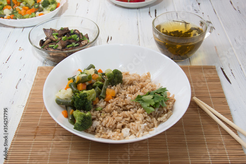 Rice with soy sauce and boiled vegetables close-up on a decorative background. Rice Dish. Fried mushrooms. Healthy eating Vegetarian food. Vegetarian dish
