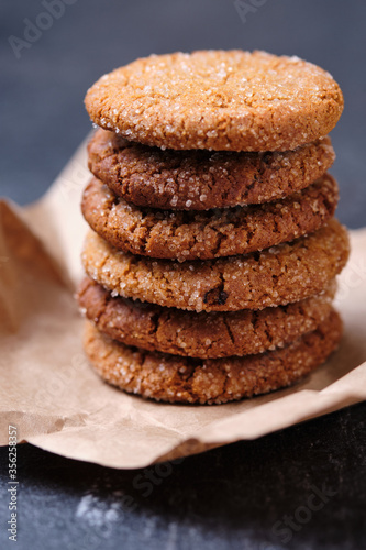 Tower of oatmeal cookies with honey. Dessert on brown paper, on the table close-up.