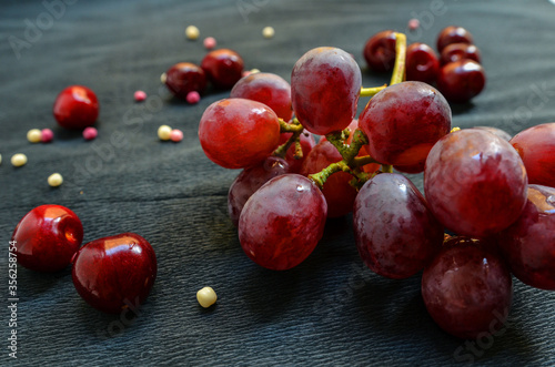 grapes and cherries on a black background