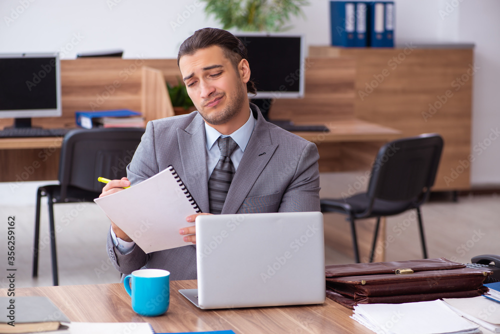 Young male employee unhappy with excessive work Young male employee unhappy with excessive work