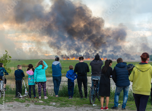 A crowd of people watching the fields burn