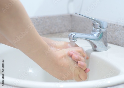 Lavado de manos, puños y dedos con jabón para prevenir propagación de virus y bacterias. Frotar con jabón y agua las manos para evitar el covid 19. 