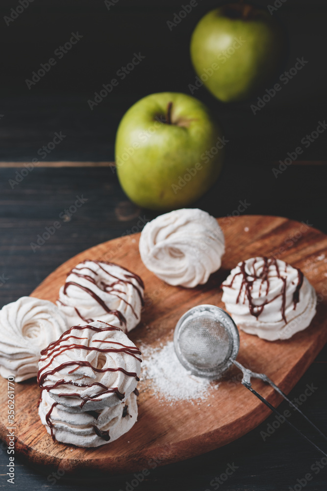 Homemade handmade apple marshmallows on a wooden board. The dessert is poured with chocolate.