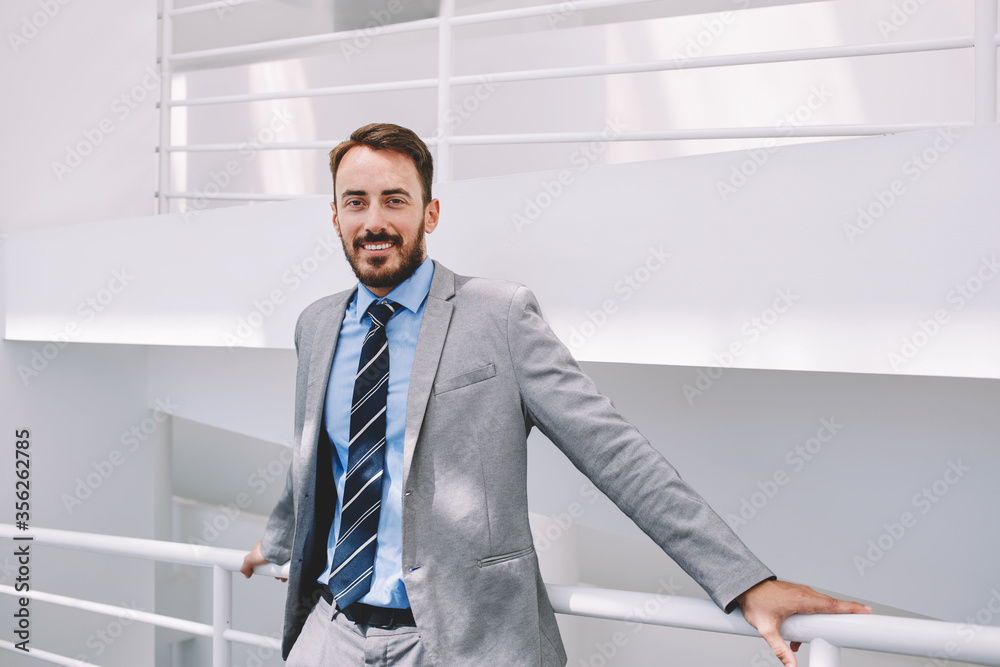 Half length portrait of rich businessman holding portable digital tablet during work break in hallway Half length portrait of rich businessman holding portable digital tablet during work break in hallway