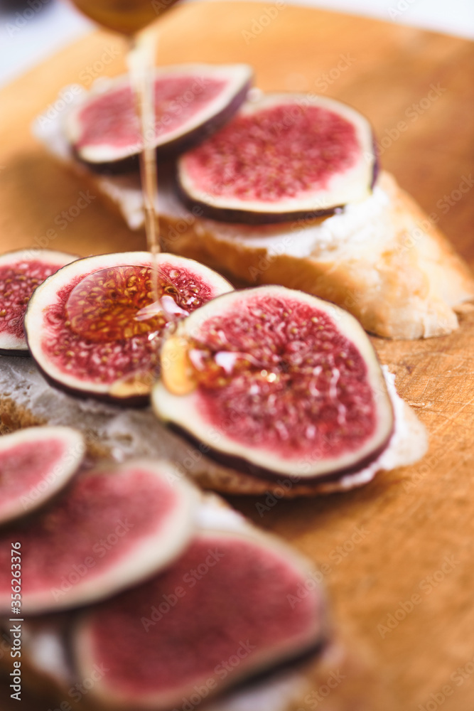 Bruschettas with figs, soft cheese and honey on a wooden board. Bruschettas with figs, soft cheese and honey on a wooden board.