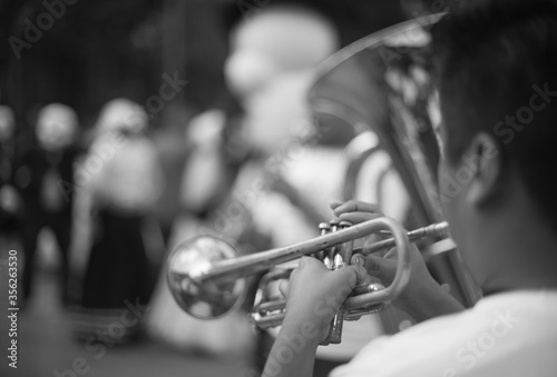 Black and white close up of a trumpet being played by a musician 