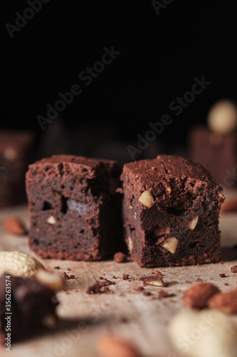 Chocolate brownie with nuts. Sweet and tasty dessert close-up on a wooden table. Soft focus.