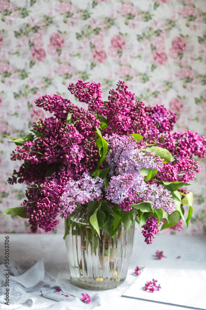 Bouquet of violet lilac in a vase. Still life with blooming branches of lilac in vases. Greeting card mock up. Space for text.