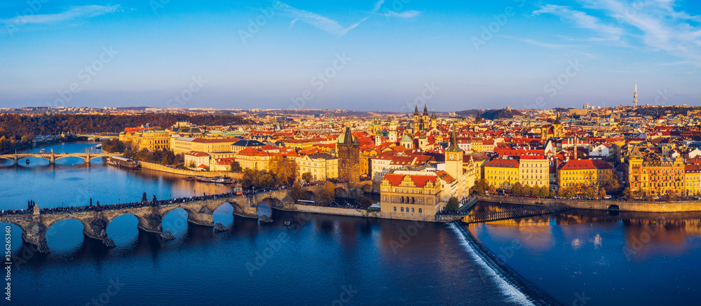Obraz premium Aerial Prague panoramic drone view of the city of Prague at the Old Town Square, Czechia. Prague Old Town pier architecture and Charles Bridge over Vltava river in Prague at sunset, Czech Republic.