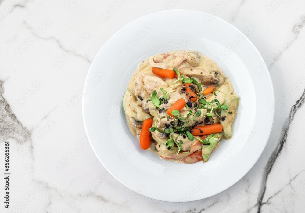 Hot salad with chicken meat, carrots, mushrooms, zucchini and cheese sauce on light marble background. Healthy food, top view Hot salad with chicken meat, carrots, mushrooms, zucchini and cheese sauce on light marble background. Healthy food, top view