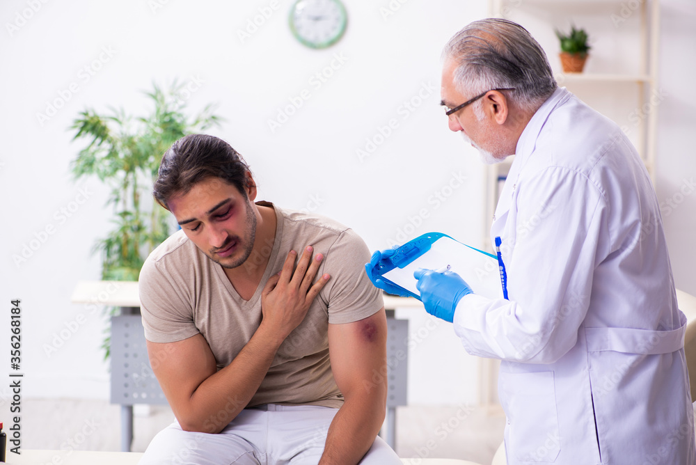 Obraz premium Young face injured man visiting experienced male doctor traumato