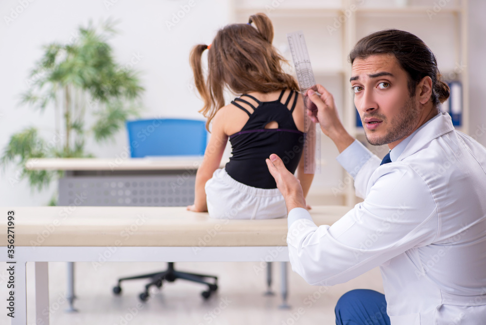 Fototapeta premium Small girl visiting young male doctor