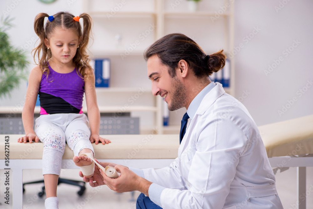 Fototapeta premium Small girl visiting young male doctor