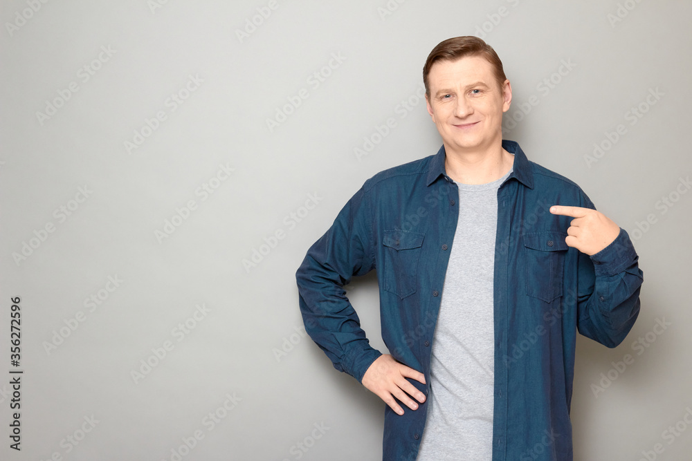 Portrait of happy mature man pointing with index finger at himself Portrait of happy mature man pointing with index finger at himself
