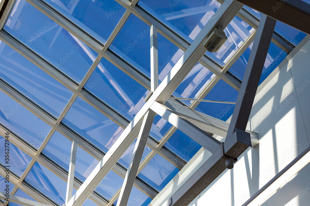 Steel frame of the glazed roof of a warehouse, shopping or office center. The ceilings are made of metal beams interconnected by bolts and welding to maintain mobility and rigidity. Steel frame of the glazed roof of a warehouse, shopping or office center. The ceilings are made of metal beams interconnected by bolts and welding to maintain mobility and rigidity.