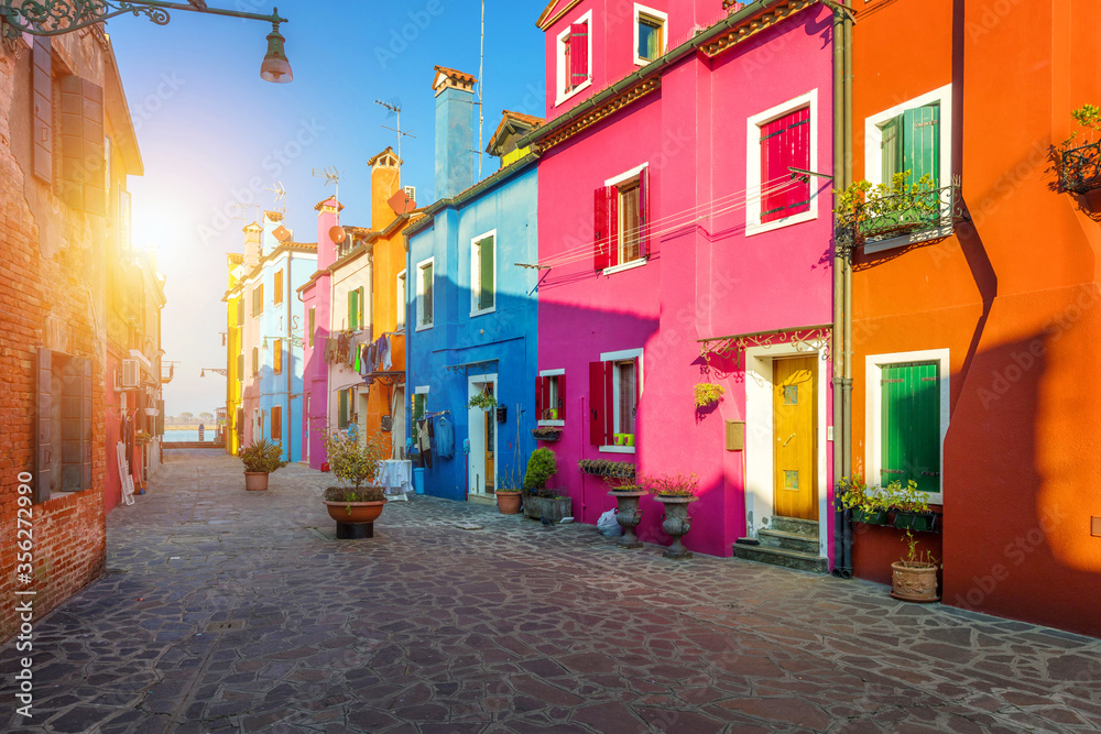 Street with colorful buildings in Burano island, Venice, Italy. Architecture and landmarks of Burano, Venice postcard. Scenic canal and colorful architecture in Burano island near Venice, Italy