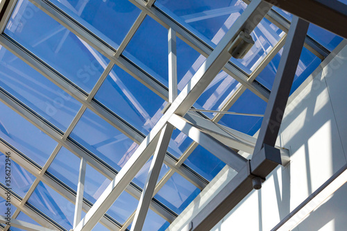 Steel frame of the glazed roof of a warehouse, shopping or office center. The ceilings are made of metal beams interconnected by bolts and welding to maintain mobility and rigidity.