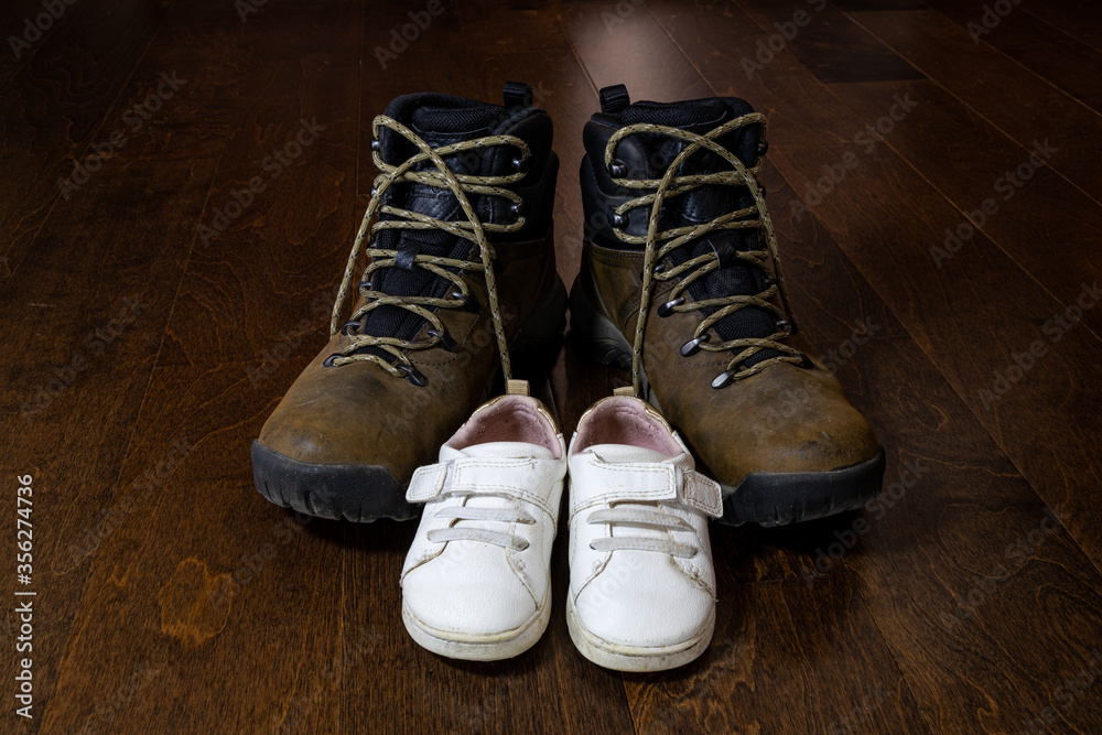 father and daughter's shoes on a wooden background