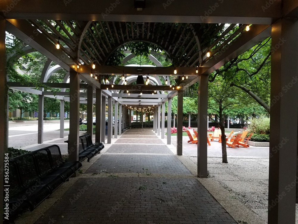 covered walkway in park with tables and chairs and lighting