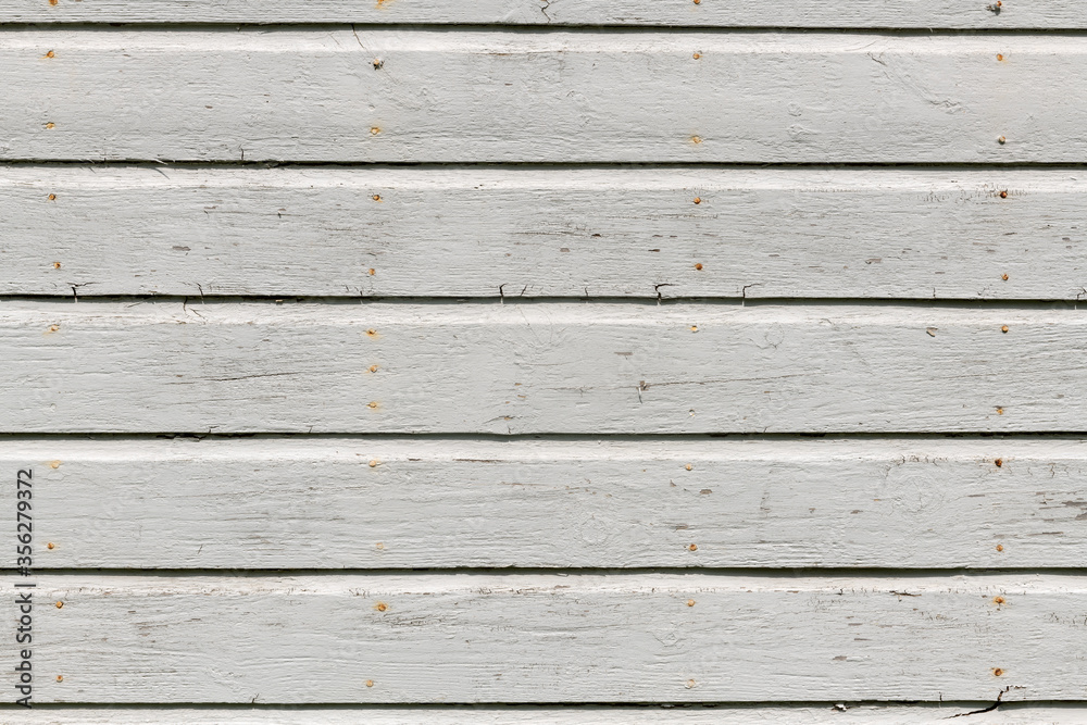 Obraz premium White wooden wall with rich texture, cracks, knots, and nails. Weathered timber planks background.