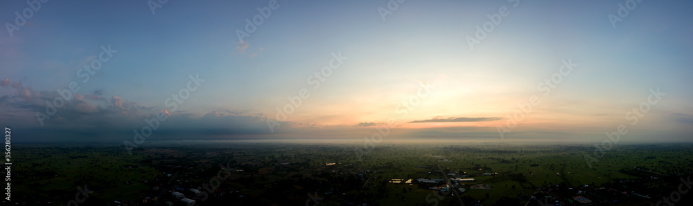 Panorama Top view Aerial photo from flying drone over village in Thailand.Top view beautiful Sunset.Sunrise with cloud over rice field.