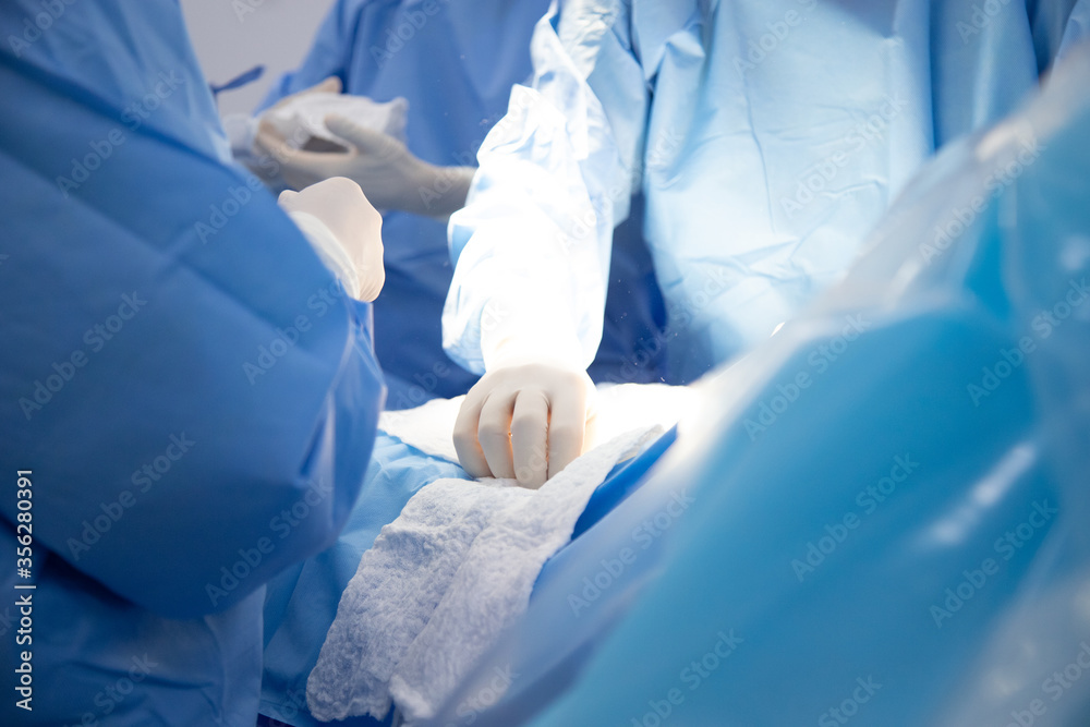 Fototapeta premium Medical team of surgeons in hospital doing caesarean