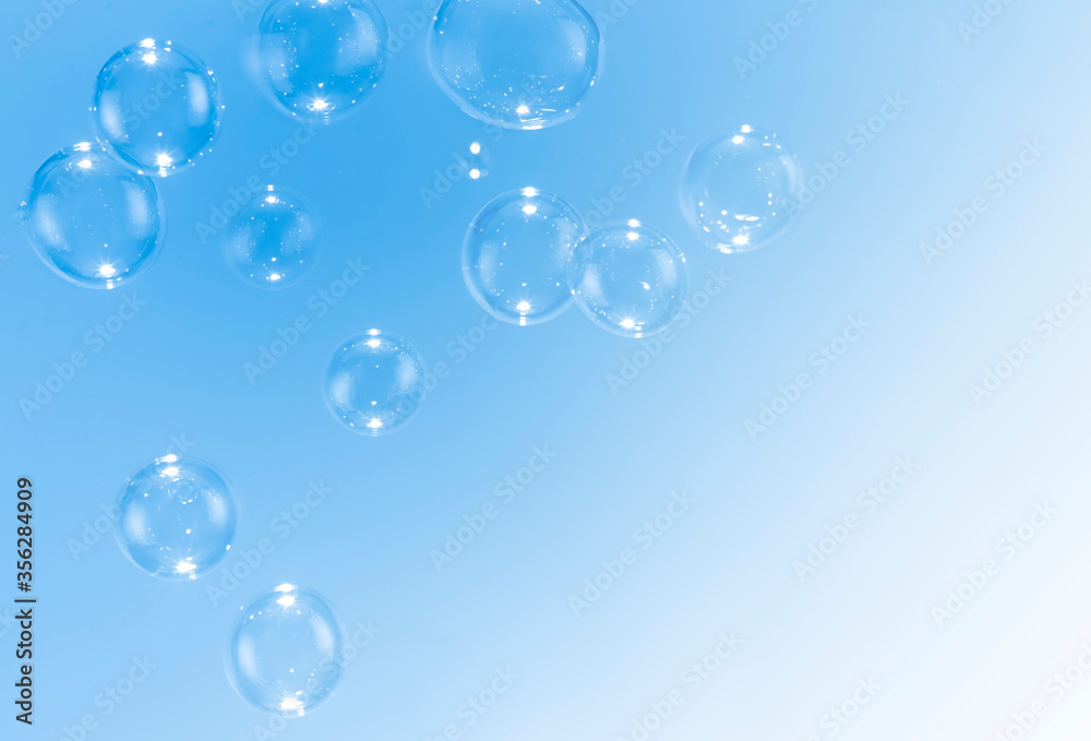 Beautiful blue soap bubbles float as background.