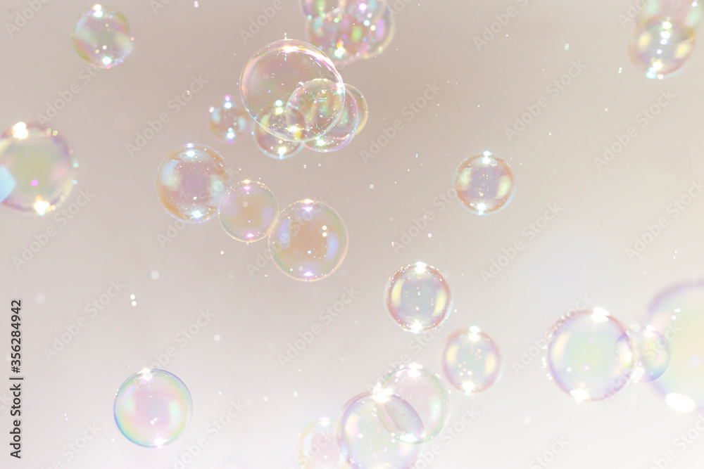 Beautiful rainbow soap bubbles float as background.