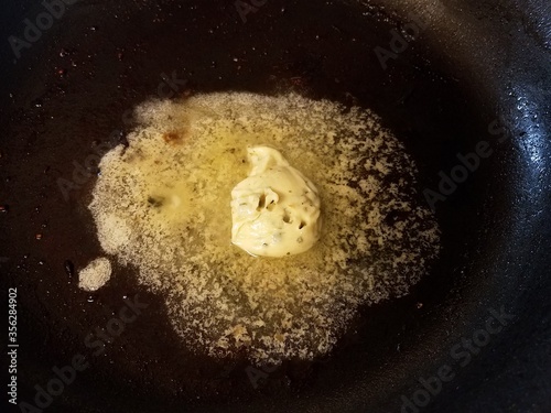 butter melting in a hot skillet or frying pan