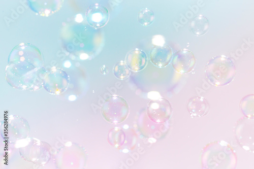 Beautiful rainbow soap bubbles float as background.