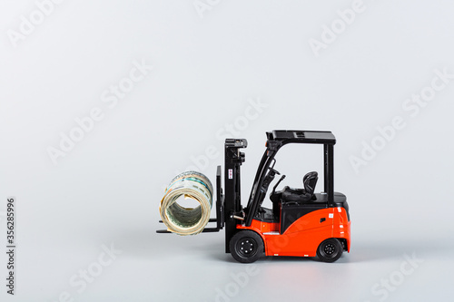 forklift with roll of dollars on gray background. Strongest financial assistance, support of business and people after coronavirus covid-19 pandemic. Mockup with copy space