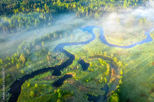 Obraz na płótnie Summer scenery aerial view. Sunrise. Beautiful view on winding river surrounded meadow and forest. Early misty morning w salonie