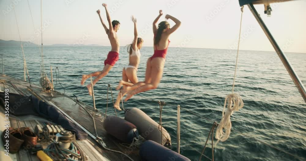 Group of young friends enjoying trip on a sailboat in the Ligurian Sea.