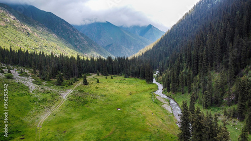 Areal view of river, green field and forest in mountains. photo
