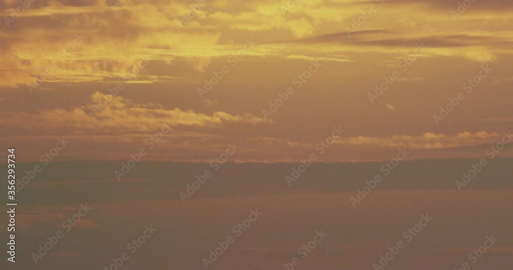 Waves breaking onto the shore below an orange sun. Waves breaking onto the shore below an orange sun.