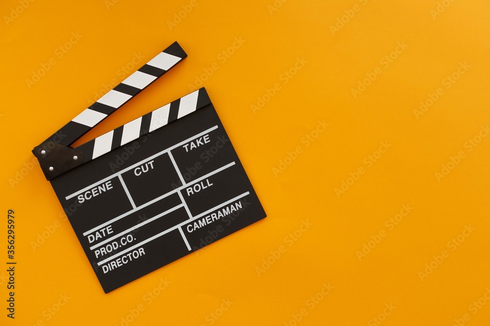 Filmmaking concept. Movie Clapperboard. Cinema begins with movie clappers. Place for your text. Yellow background.