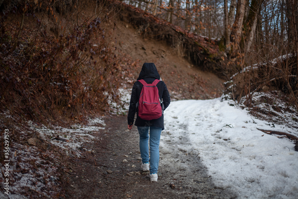 A girl walks through the woods A girl walks through the woods