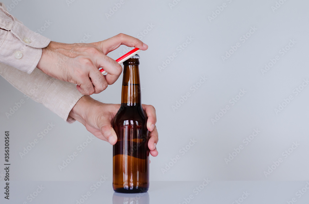 Hand opening a bottle of beer for International beer day concept. Hand opening a bottle of beer for International beer day concept.