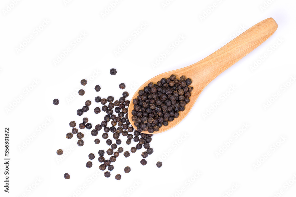 Closeup black pepper seeds or peppercorns ( dried seeds of piper nigrum) in wooden spoon isolated on white background. top view. Flat lay. Closeup black pepper seeds or peppercorns ( dried seeds of piper nigrum) in wooden spoon isolated on white background. top view. Flat lay.