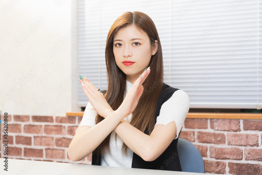 NGのジェスチャーをする若い女性