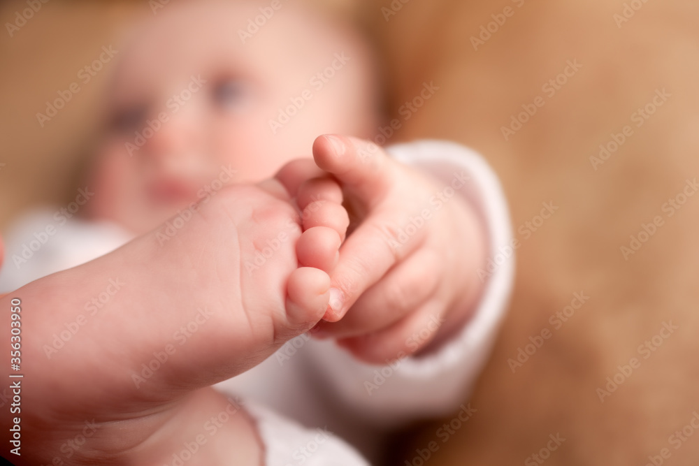 Baby reaching with its hand for its toes Baby reaching with its hand for its toes
