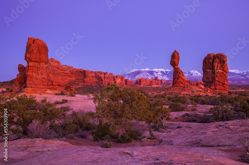 Balanced Rock with the snow-capped LaSal Mountains in the background at twilight at Arches National Park near Moab, Utah photo